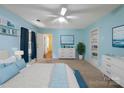Serene bedroom with blue walls, carpet floors, built-in shelving, and a large window creating a peaceful retreat at 4325 Wolf Pond Rd, Monroe, NC 28112