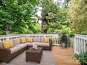 Inviting outdoor deck with comfortable seating and neutral tones, surrounded by lush greenery for a relaxing ambiance at 4325 Wolf Pond Rd, Monroe, NC 28112
