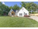 Charming white farmhouse with well-maintained landscaping and inviting curb appeal at 518 Maynard Farm Ln, Stanley, NC 28164