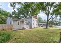 Landscaped property featuring mature trees, gray siding, and a well-maintained lawn at 5421 Princess St, Charlotte, NC 28269