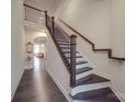 Elegant staircase with dark wood treads, rod iron railing, and white risers at 5918 Barrowlands Ct, Charlotte, NC 28210