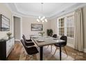 Formal dining room showcasing a modern chandelier, large windows, and elegant decor at 709 Cavesson Way, Monroe, NC 28110