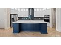 Modern kitchen featuring white cabinets, a blue island, and stainless steel appliances at 709 Cavesson Way, Monroe, NC 28110