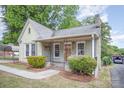 Lovely home showcasing a brick facade, covered porch, and quaint landscaping at 813 S Ridge Ave, Kannapolis, NC 28083