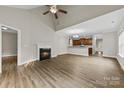 Spacious living room featuring a fireplace, high ceilings, and hardwood floors, flowing into the kitchen at 8505 Loxton Cir, Charlotte, NC 28214