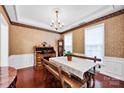 Elegant dining room with wood floors, wainscoting, decorative wallpaper, and a unique dining set at 8938 Kestral Ridge Dr, Charlotte, NC 28269