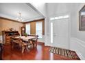 Open concept dining room with wood floors, decorative wallpaper, and a view of the home's front entrance at 8938 Kestral Ridge Dr, Charlotte, NC 28269