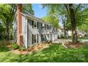 Landscaped side view of a lovely two-story home with a brick chimney and manicured lawn at 9238 Deer Spring Ln, Charlotte, NC 28210