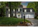 Charming two-story home at dusk with a well-manicured lawn, two-car garage and lovely landscaping at 9238 Deer Spring Ln, Charlotte, NC 28210