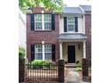 Charming brick townhome with black shutters and an inviting entrance featuring a small decorative fence at 9532 Cadman Ct, Cornelius, NC 28031