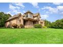 Well-maintained home features brick and stone exterior with a sprawling green lawn at 1010 Nutall Oak Ln, Belmont, NC 28012