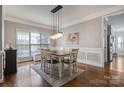 Elegant dining room with modern lighting fixture, wainscoting and hardwood floors at 104 Steamboat Dr, Mount Holly, NC 28120