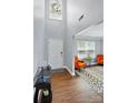 Welcoming foyer with soaring ceilings, wood floors, stylish chandelier, and a pop of color with orange chairs at 10431 Plantain Ct, Charlotte, NC 28213