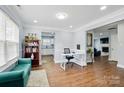 Open concept living area with hardwood floors, blue sofa and views into the adjacent kitchen at 10431 Plantain Ct, Charlotte, NC 28213