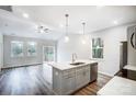 Modern kitchen with stainless steel appliances, island with sink, and open layout to the living room at 112 Bickett Ave, Gastonia, NC 28052
