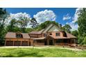 Charming home with a welcoming front porch, three-car garage and manicured lawn under a cloudy blue sky at 1140 Fern Hill Rd, Mooresville, NC 28117
