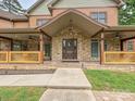 Charming stone and siding home featuring a covered porch with decorative railing and inviting front door at 1140 Fern Hill Rd, Mooresville, NC 28117