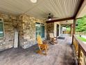 Inviting front porch with stone accents, ceiling fan, stamped concrete floor, and rocking chairs at 1140 Fern Hill Rd, Mooresville, NC 28117