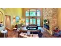 Spacious living room boasts soaring windows, stone fireplace, hardwood floors, and comfortable furnishings at 1140 Fern Hill Rd, Mooresville, NC 28117