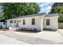 Charming single-story home features a white exterior, well-manicured landscaping, and a newly paved driveway at 1218 E Woodlawn Rd, Charlotte, NC 28209