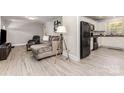 Open concept living room with modern gray tones and adjacent kitchen featuring stainless steel appliances at 1218 E Woodlawn Rd, Charlotte, NC 28209