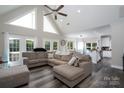 Open-concept living room with vaulted ceilings, large windows, and stylish, neutral toned furniture at 126 Strand Rd, New London, NC 28127