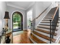 Inviting foyer with hardwood floors, staircase, and an elegant arched doorway leading to the outside at 12835 Ninebark Trl, Charlotte, NC 28278