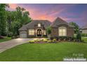 Beautiful brick home boasts a manicured lawn and lush landscaping in a desirable community at 1400 Delaney Dr, Matthews, NC 28104