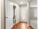 Bright entryway featuring hardwood floors, white trim, and half bathroom at 14010 Pinyon Pine Ln, Charlotte, NC 28215