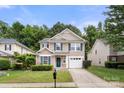 Inviting two-story home with green shutters and lush green landscaping at 14010 Pinyon Pine Ln, Charlotte, NC 28215