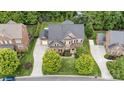 A bird's-eye view of a brick house, showcasing its manicured lawn, driveway, and surrounding trees at 16109 Reynolds Dr, Indian Land, SC 29707