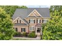 Aerial front view of a two-story brick home with a dark roof and mature trees surrounding the property at 16109 Reynolds Dr, Indian Land, SC 29707
