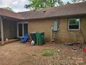 Spacious backyard with brick, featuring a chair and garbage cans for functional outdoor living at 1700 Old Towne Ct, Charlotte, NC 28217