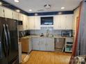 Bright kitchen featuring white cabinets, granite countertops, and stainless steel appliances at 1700 Old Towne Ct, Charlotte, NC 28217