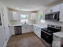 Bright kitchen featuring white cabinets, stainless steel appliances and wood flooring at 1900 Walkup Ave # 1, Monroe, NC 28110