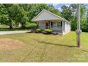 Single-story home featuring a charming front porch, a red front door, and a manicured lawn and shrubbery at 201 Easy St, Concord, NC 28027