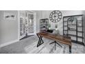 Office featuring a dark wooden desk, a light-colored carpet, and a large clock on the wall at 2025 Masons Bend Dr, Fort Mill, SC 29708