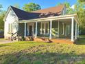 Lovely home with a large front porch, classic columns, green siding, and a well-manicured lawn at 222 Brevard St, Statesville, NC 28677