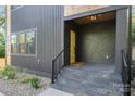 Inviting front porch with stylish grey tile steps and a vibrant yellow door at 2224 Highland St, Charlotte, NC 28208