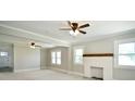 Bright living room with white painted brick fireplace, large windows, and ceiling fans at 2306 W C St, Kannapolis, NC 28081
