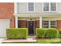 Inviting front entrance featuring manicured hedges and a classic dark-colored front door at 312 Farm Springs Dr, Mount Holly, NC 28120