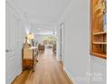 Bright hallway featuring wood floors and leading to a living room with comfortable seating at 312 Farm Springs Dr, Mount Holly, NC 28120