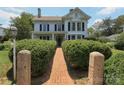 Charming two-story home featuring a brick pathway and manicured hedges at 321 W Bank St, Salisbury, NC 28144