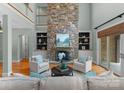 Bright living room with a stone fireplace, built-in shelving, and hardwood floors at 3815 Stoney Ridge Trl, Charlotte, NC 28210