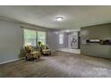 Open concept living area with plush carpeting and a seamless flow into the adjacent kitchen space at 413 N Mulberry St, Cherryville, NC 28021