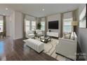Well-lit living room featuring hardwood floors, a large TV, and neutral furniture at 437 Bent Burr Crk, York, SC 29745