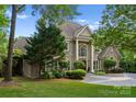Elegant home with a circular driveway, mature trees, and well-maintained lawn at 4429 Cameron Oaks Dr, Charlotte, NC 28211