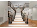 Grand foyer showcasing a split staircase with hardwood floors and decorative railing at 4429 Cameron Oaks Dr, Charlotte, NC 28211