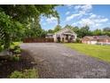 View of exterior featuring wide gravel driveway, a well-maintained lawn, and attractive landscaping at 5252 Ramblewoods Ave, Claremont, NC 28610