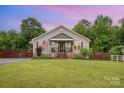 Charming single-Gathering home boasts a well-manicured lawn and cozy, covered front porch with brick steps at 5252 Ramblewoods Ave, Claremont, NC 28610